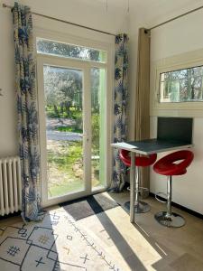 a room with a table and two chairs and a window at Mas Élunia, Gites et Chambres d'hôtes, entre Mer et Montagne in Argelès-sur-Mer