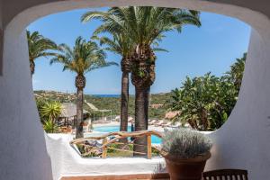 a resort with palm trees and a pool at Hotel Balocco in Porto Cervo