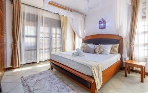 a bedroom with a large bed in a room with windows at Savannah Bstan Luxury Apartment in Diani Beach +29 photos