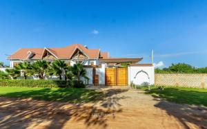 a house with a gate and a fence at Savannah Bstan Luxury Apartment in Diani Beach