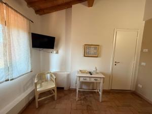 a small room with a table and a television on the wall at Poggio Savelli in Scarperia +58 photos
