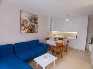 a living room with a blue couch and a table at Amaris-Kian Tragaj Apparent in Vlorë