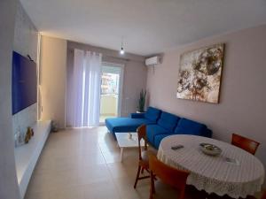 a living room with a blue couch and a table at Amaris-Kian Tragaj Apparent in Vlorë