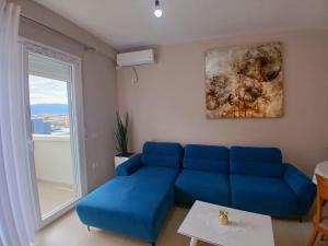 a blue couch in a living room with a window at Amaris-Kian Tragaj Apparent in Vlorë