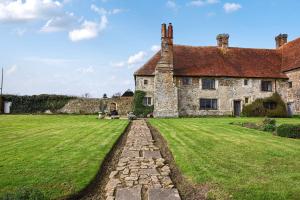 an old stone house with a grassy yard at The William Penn At Wickham Manor in Winchelsea