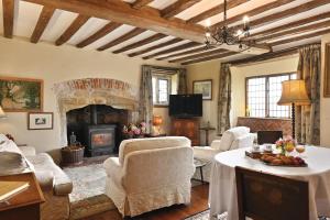 a living room with white furniture and a fireplace at The William Penn At Wickham Manor in Winchelsea