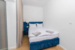 a small bedroom with a blue and white bed at Apartamenty Mazurska Strefa in Pisz