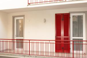 a red door on a building with a balcony at Ledy Apartment in Lovere
