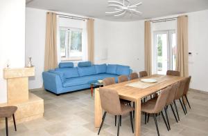 a living room with a blue couch and a table at Villa Luce Relax by Perle di Puglia in Villa Castelli