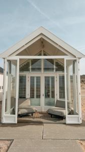 a pavilion with glass doors and windows on a patio at SandCsleep in Katwijk