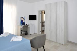 a room with a bed and a desk with a television at Villa Luce Relax by Perle di Puglia in Villa Castelli