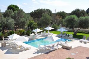 a swimming pool with lounge chairs and umbrellas at Villa Luce Relax by Perle di Puglia in Villa Castelli