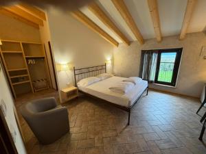 a bedroom with a bed and a chair in it at agriturismo2laghi in Ponti Sul Mincio