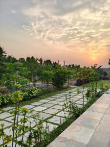 a stone pathway with a sunset in the background at Cherish Farm Stay in Medchal