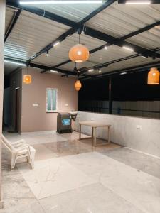 a large room with a table and a tv in it at Cherish Farm Stay in Medchal