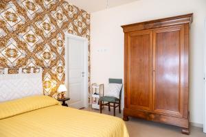 a bedroom with a bed and a wooden cabinet at Alloggio Turistico Porta di Poggio in Tuscania