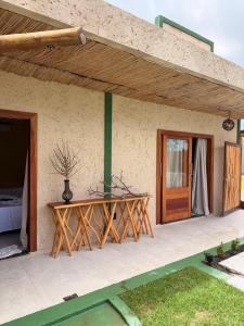 a wooden table on the outside of a house at Pousada Verdes dos Corais in São Miguel dos Milagres