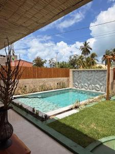 a swimming pool in a yard next to a fence at Pousada Verdes dos Corais in São Miguel dos Milagres