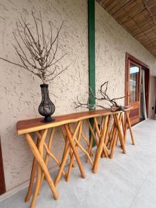 a row of wooden tables with a vase on top at Pousada Verdes dos Corais in São Miguel dos Milagres