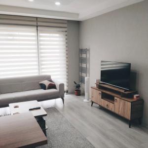a living room with a couch and a flat screen tv at Ankara Esenboğa Airport Comfort Apart in Ankara