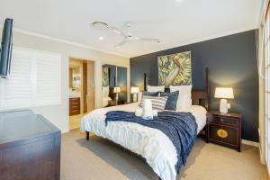 a bedroom with a large bed with a blue blanket at Oceanfront Spa Suite - Sub Penthouse in Urangan