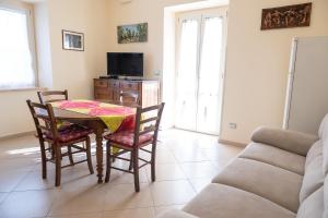 a dining room with a table and chairs and a couch at Alloggio Turistico Porta di Poggio in Tuscania