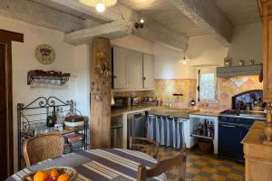 a kitchen with a table and a kitchen with blue appliances at Le Clos Lau-Tave Charming 110 m Provençal home with private garden in Simiane-la-Rotonde