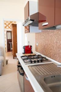 a kitchen with a stove with a red bag on it at Alloggio Turistico Porta di Poggio in Tuscania