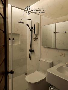 a bathroom with a shower and a toilet and a sink at Minnie's Guest House in Taytay +21 photos