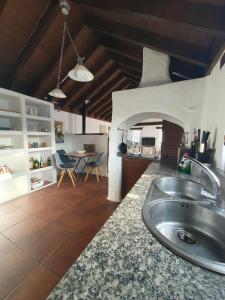 a kitchen with a sink and a living room at Casa MaLuMi - Historisches Stadthaus in Haría in Haría