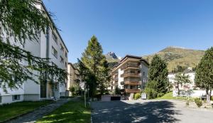 une rue dans une ville avec des montagnes en arrière-plan dans l'établissement Belezza, à Davos