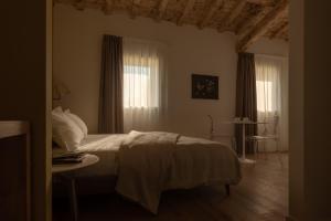 a bedroom with a bed and a table and windows at Agriturismo Relais Maddalene101 in Vicenza +45 photos