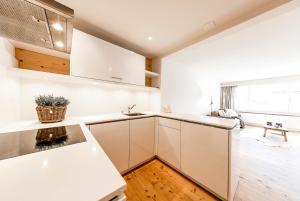 a kitchen with white cabinets and a large window at Belezza in Davos