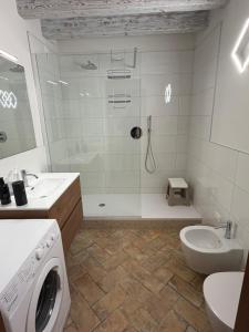 a bathroom with a shower and a washing machine at agriturismo2laghi in Ponti Sul Mincio