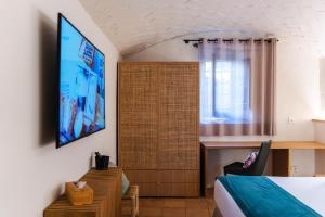 a bedroom with a bed and a tv on a wall at Hotel Boutique Monells Summum in Monells