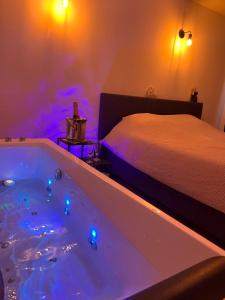 a bathtub with lights in a bedroom with a bed at La Bouverie in Profondeville