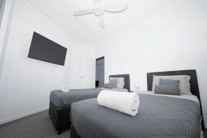 a bedroom with two beds and a ceiling fan at Rooftop Apartment - Heated Pool & Beach access in Marcoola +10 photos