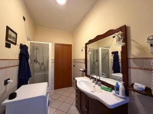 a bathroom with a sink and a shower and a mirror at Guest House Colfiorito by Ospitaci in Colfiorito