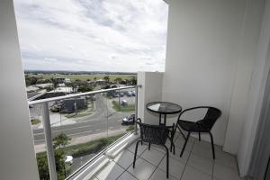 a balcony with two chairs and a view of a street at Rooftop Apartment - Heated Pool & Beach access in Marcoola