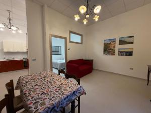 a living room with a table and a red chair at Guest House Colfiorito by Ospitaci in Colfiorito