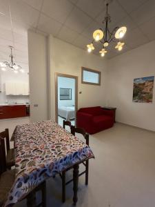 a room with a table and a red couch at Guest House Colfiorito by Ospitaci in Colfiorito +13 photos