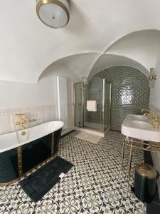 a bathroom with two sinks and a tub and a shower at Boutique Hotel H23 in Pezinok