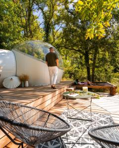 a man walking on a wooden deck with a glass dome at Somn'en Bulle in Najac