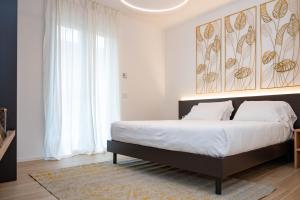 a bedroom with a large bed with white sheets at Ariom Apartments in Moniga