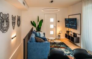a living room with a blue couch and a tv at Ariom Apartments in Moniga