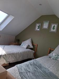 a bedroom with two beds and pictures on the wall at Cottage en Saule in Port-Launay