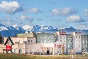 a hotel with snow covered mountains in the background at Ramada by Wyndham Hinton in Hinton