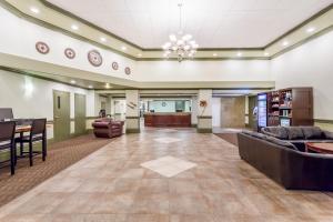 eine große Lobby mit einem Sofa und einem Tisch in der Unterkunft Ramada by Wyndham Hinton in Hinton