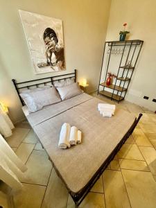 a bed with two towels on it in a room at Suite Altura in Cuneo