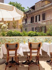 a table and chairs on a patio with a table and a building at Casa Monti Roma in Rome